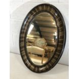 Large oval ebony-framed bevel edged mirror approx 86cm x 59cm (A/F)