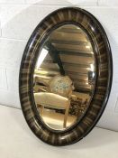 Large oval ebony-framed bevel edged mirror approx 86cm x 59cm (A/F)