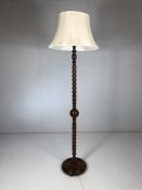 Carved wooden standard lamp with spiralling snake and ball relief design and cream shade