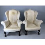 Pair of wing backed fireside armchairs on ball and claw feet in need of restoration