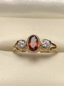 Three stone 9ct gold ring set with a central Oval Garnet (size 'J')
