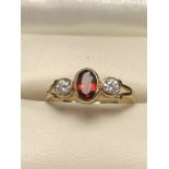 Three stone 9ct gold ring set with a central Oval Garnet (size 'J')