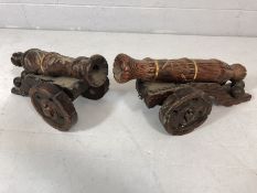Two wooden carved and brass-bound cannons, the larger approx 52cm in length