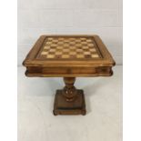 Light wood Chess table on turned pedestal base with drawer containing Chess pieces