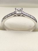 18ct White Gold and Diamond ring with central square cut Diamond and eight Diamonds to each shoulder