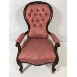 Victorian nursing chair on original casters with pink button back upholstery