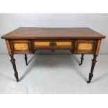 Three drawer Regency desk on ornately craved legs with castors, the drawers having Birdseye maple