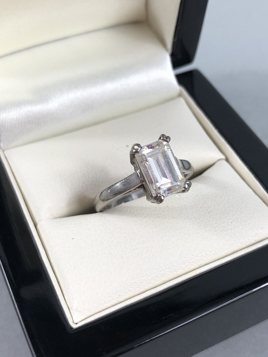 White Metal (Stamped 18ct) and set with a Step Cut CZ stone. Size: ‘L’ UK, ‘5½’ USA.