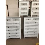 White wood and wicker bedroom furniture , consisting of two chests of seven drawers , and two