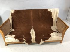 Bergere two seater sofa with genuine Cowhide Throw