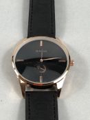 Rose Gold black face watch with suede strap marked RADO