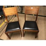 Pair of teak framed dining chairs with Black padded seats