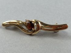 9ct Gold marked 375 Brooch set with central faceted Garnet and a single Diamond
