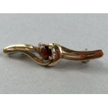 9ct Gold marked 375 Brooch set with central faceted Garnet and a single Diamond