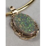 Single Collet pendant with a wavy frame edge of yell swags, set with an oval cabochon cut Opal and