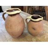 Two rustic terracotta jugs with unglazed bodies and glazed two-tone rims