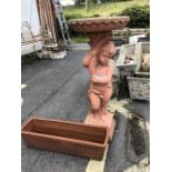 Terracotta coloured cherub bird bath along with a terracotta planter