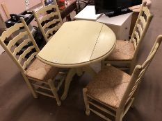 Drop leaf painted pine table with four rush-seated ladder back chairs