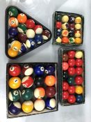 Three sets of pool balls including a full size set, plus a set of snooker balls