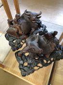 Two carved Water Buffalo on ebonised plynths (A/F)