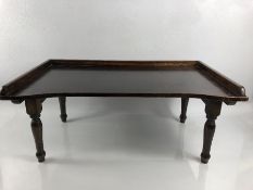 An Edwardian mahogany breakfast tray with folding leg