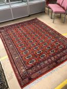 Red ground rug with blue and orange detailing approx 230cm x 170cm