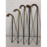 Five walking canes, one with silver handle tip and collar