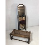 Carved dark wood vintage cheval mirror on original castors along with a cane seated oblong stool