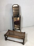 Carved dark wood vintage cheval mirror on original castors along with a cane seated oblong stool