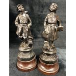 Pair of figurines of wooden plinths both marked Ecolier, approx 28cm tall