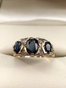 9ct Gold three stone sapphire and Diamond ring, a large central Sapphire with diamond spacers,