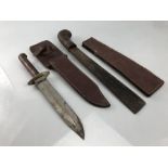 A military knife and a military issue machete both with leather sheaths