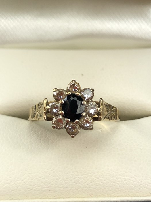 9ct Gold hallmarked Daisy ring set with an oval Sapphire and surrounded by eight Diamonds size 'N'