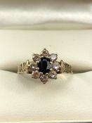 9ct Gold hallmarked Daisy ring set with an oval Sapphire and surrounded by eight Diamonds size 'N'