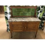 Oak wash stand on castors with marble top, green tiled splashback and two cupboards under