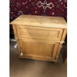 Antique pine cupboard with opening top section and cupboard under, on bun feet