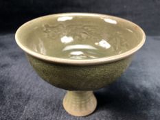 Celadon Chinese cup on stem with internal dragon design and leaf pattern to exterior, approx 12cm