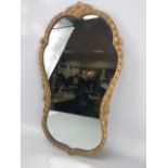 Gilt framed hourglass shaped mirror