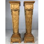 A pair of ornate walnut pedestals, of tapered form, with black marble tops and ormolu mounts, on a