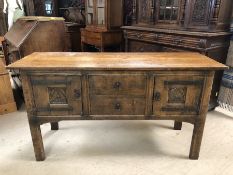 Carved oak sideboard with metal detailing, two drawers to the centre, flanked by two cupboards