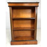 Small wooden bookcase with three shelves and black detailing, with pierced metal upstand to top,