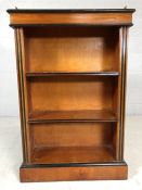 Small wooden bookcase with three shelves and black detailing, with pierced metal upstand to top,