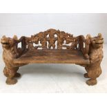 A Black forest style low bench, with two bears flanking a carved back and solid seat, approx 120cm x