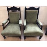 Two antique carved wooden armchairs on castors, upholstered in green fabric
