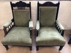 Two antique carved wooden armchairs on castors, upholstered in green fabric