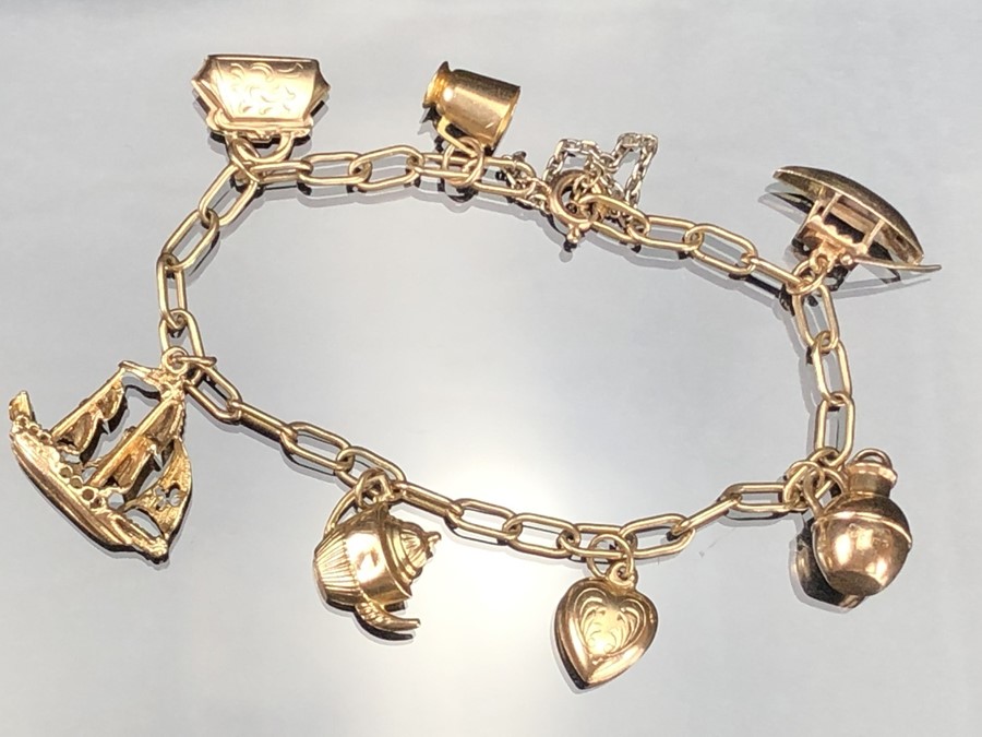 9ct Gold charm bracelet with seven gold charms (the boat marked for 14ct). total weight approx 12.