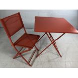 Modern metal outdoor table in orange with single chair