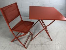 Modern metal outdoor table in orange with single chair