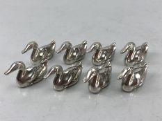 Eight silver coloured heavy placeholder card holders in the shape of ducks in a John Somers Box
