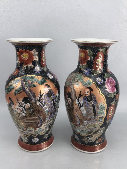 Pair of Chinese vases with red and blue colourway depicting Chinese figures, orange stamps to